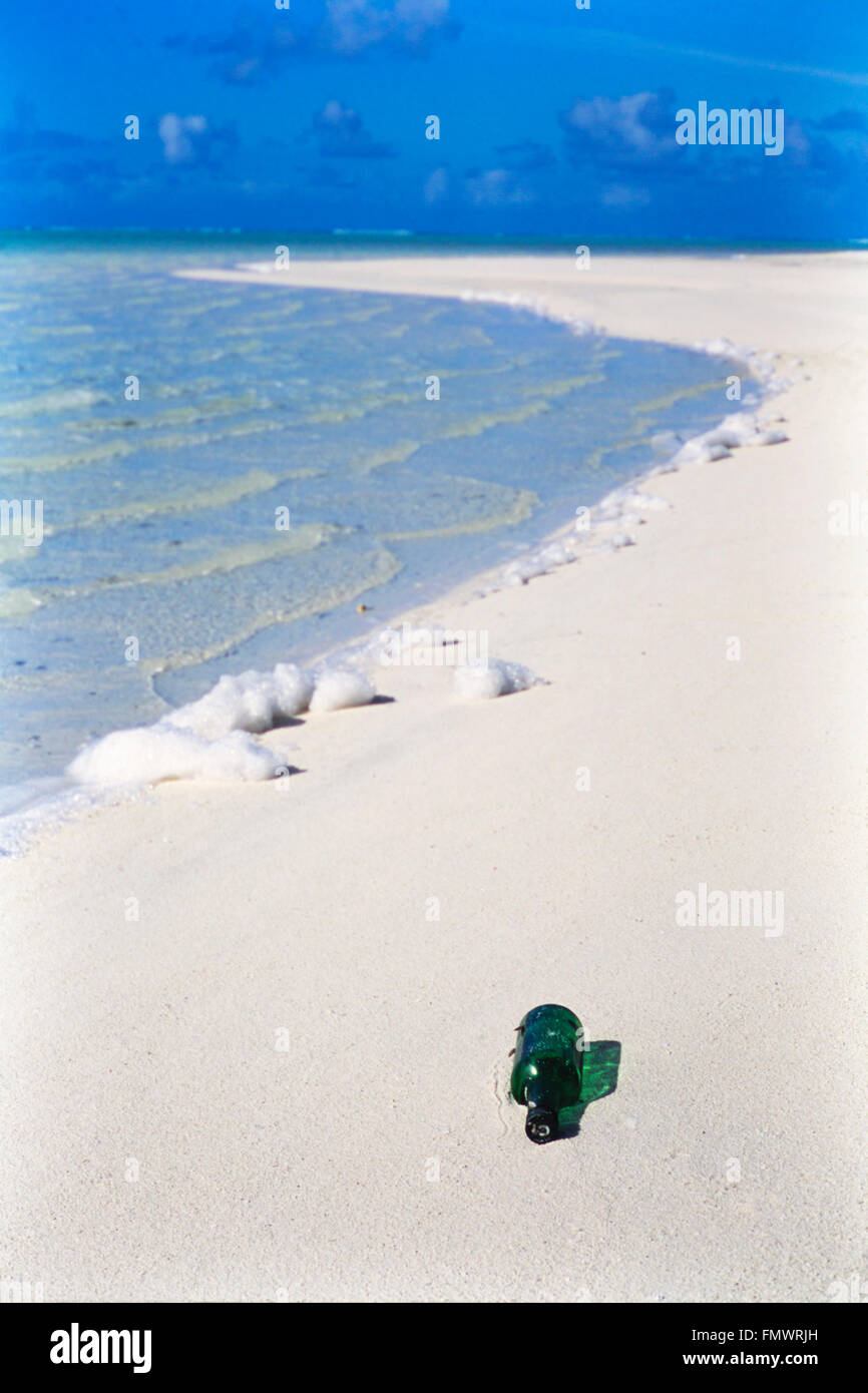 Green glass bottle washed ashore on a pristine Cook Islands beach in the South Pacific Ocean Stock Photo
