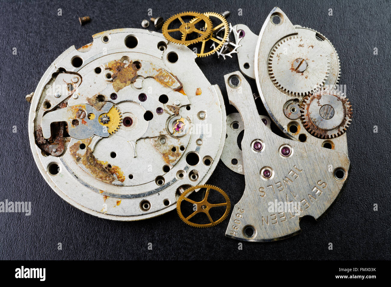 Old and broken wristwatch disassembled movements Stock Photo