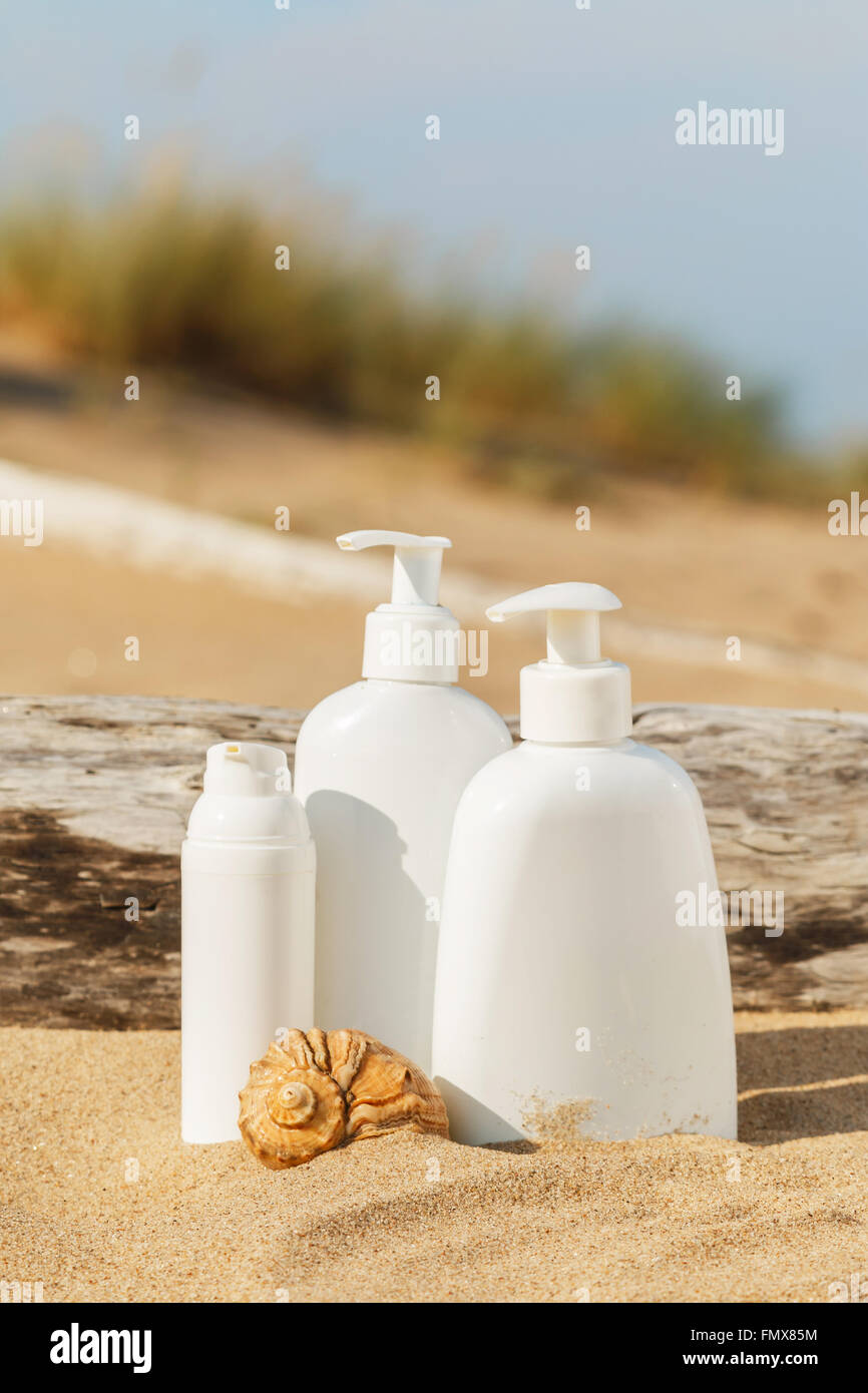 White bottles of cosmetics on the beach Stock Photo