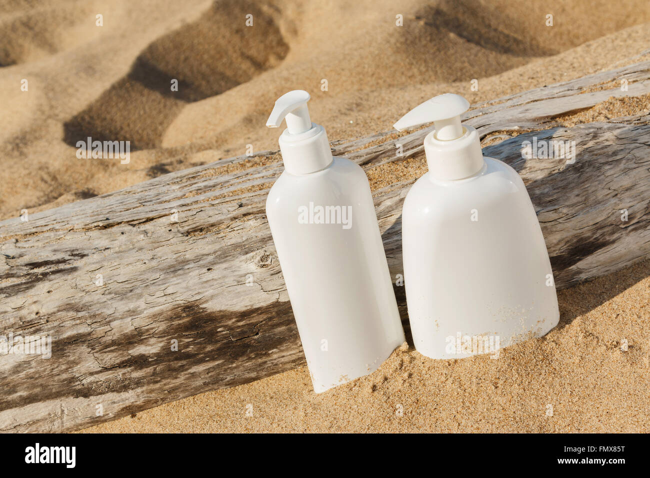 White bottles of cosmetics on the beach Stock Photo