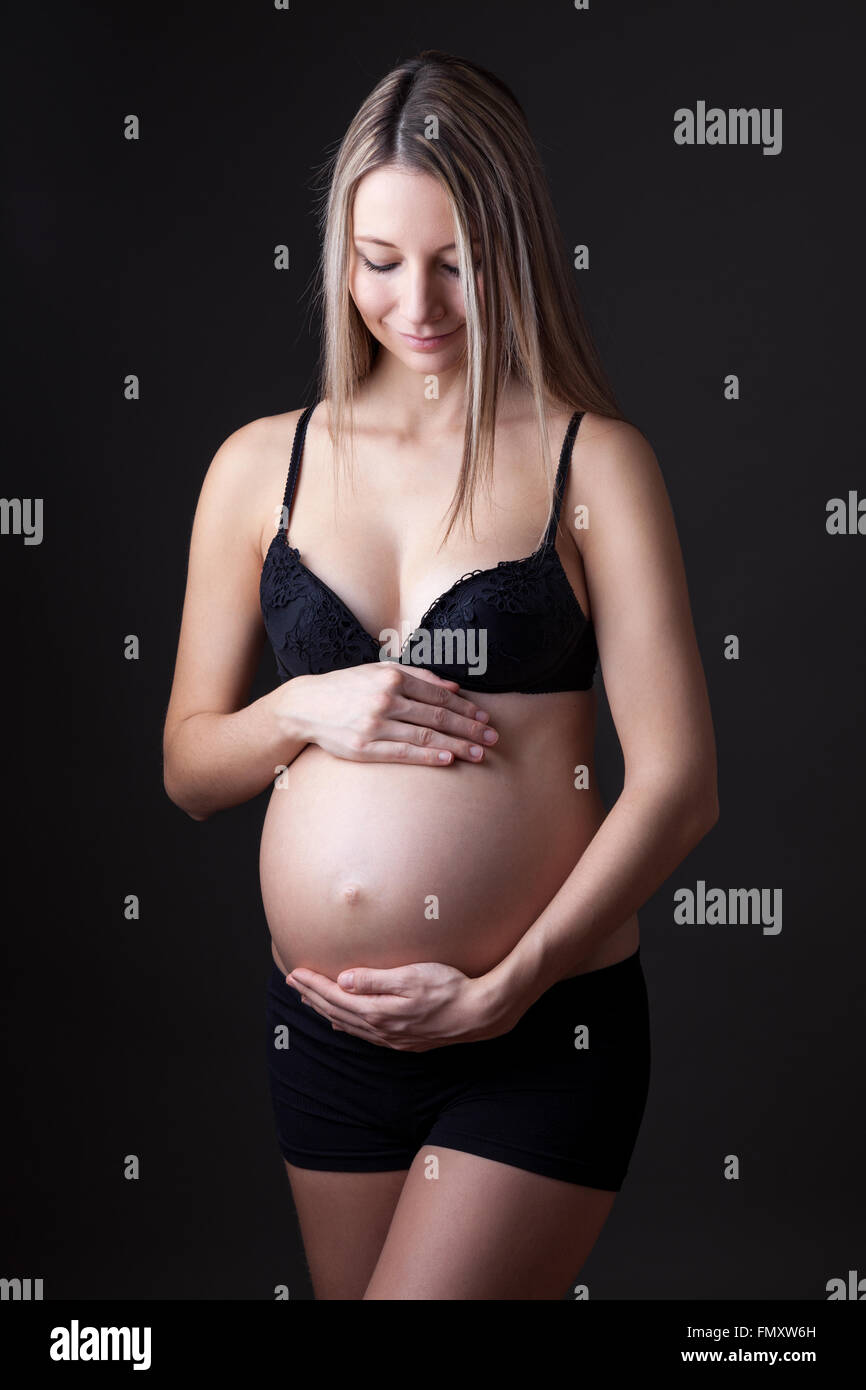Portrait of a pregnant woman holding her belly Stock Photo - Alamy