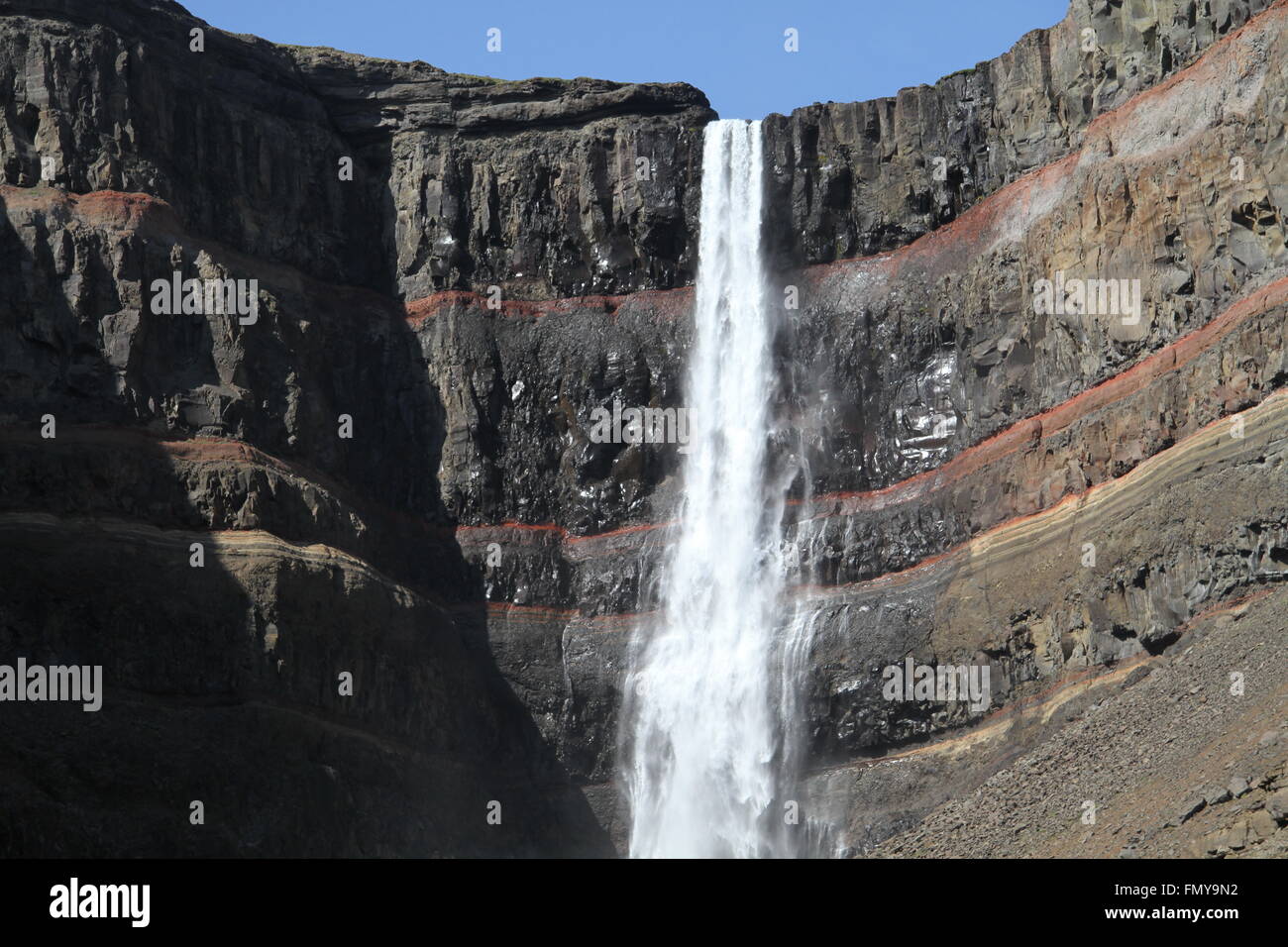 Hengifoss - a waterfall in eastern Iceland with striped sediment layers in a basalt cliff Stock Photo