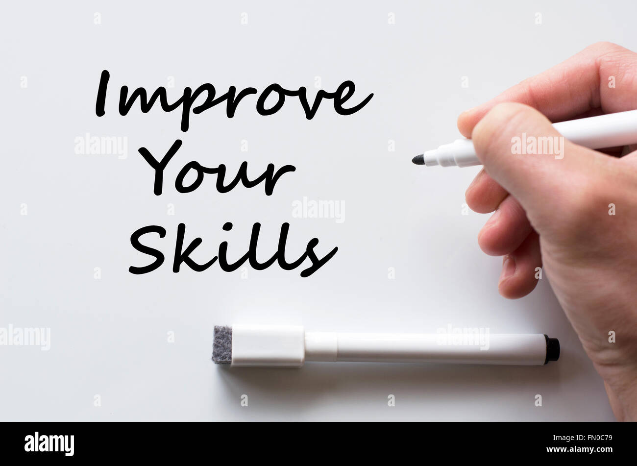 Human hand writing improve your skills on whiteboard Stock Photo - Alamy