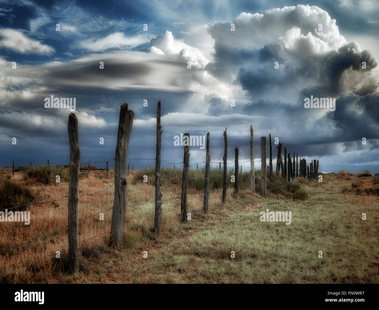 Fence line and thunderstorm clouds near Coal Mine Canyon, Arizona Stock Photo