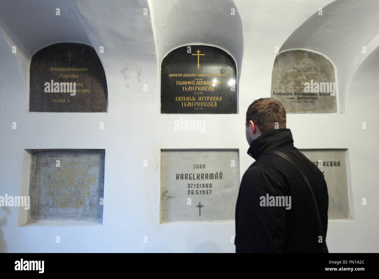 Russian historian Konstantin Gerbeev examines the burial place of Karel Kramar, the first Prime Minister of Czechoslovakia, in the underground crypt of the Dormition Church at the Olsany Cemetery in Prague, Czech Republic. Karel Kramar, born on December 17, 1860, was a Czech (Bohemian) politician and the first Prime Minister of Czechoslovakia from November 1918 to July 1919. He died at age 76 on May 26, 1937, and was buried next to his Russian wife Nadezhda Kramar, who died five months earlier at age 73. Grave of Russian art historian Nikodim Kondakov is seen at the left. Stock Photo