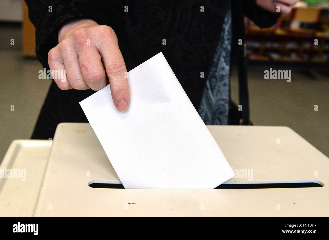 Ludwigsburg, Germany. 13th Mar, 2016. A woman places her ballot in the ballot box for the Baden-Wuerttemberg state elections a polling station in Ludwigsburg, Germany, 13 March 2016. Photo: THOMAS KIENZLE/dpa/Alamy Live News Stock Photo