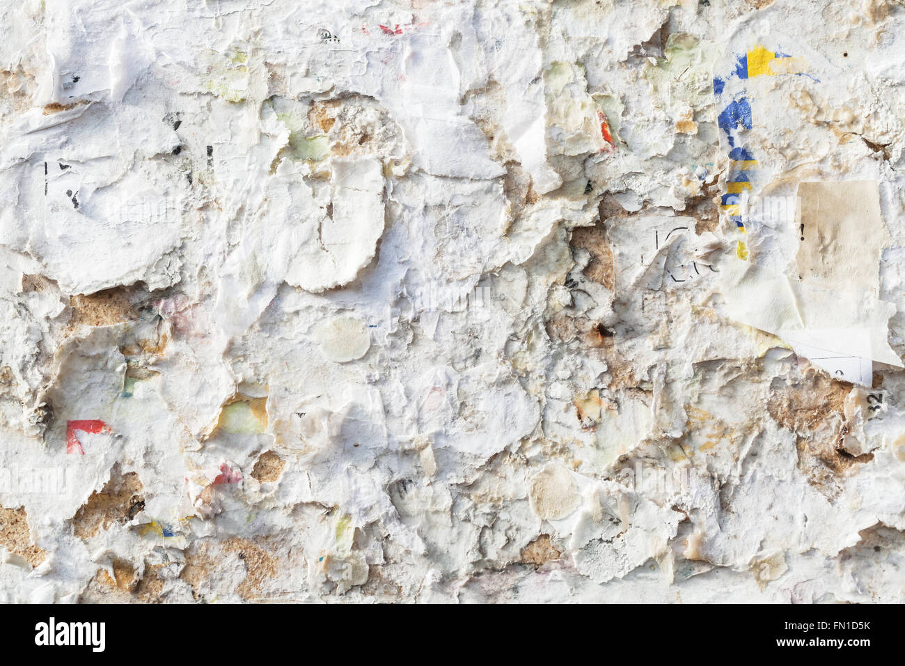 Empty public bulletin board with scraps of old advertisement posters and announcing Stock Photo