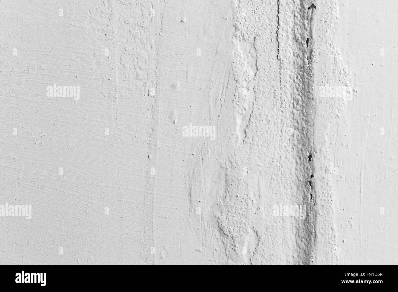 Vertical crack in white painted wall, closeup photo texture Stock Photo