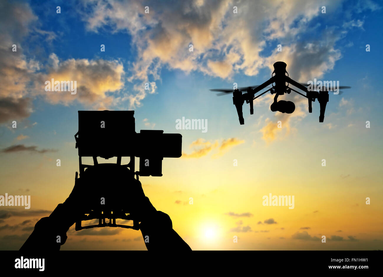 Man hands handling drone in sunset silhouettes Stock Photo