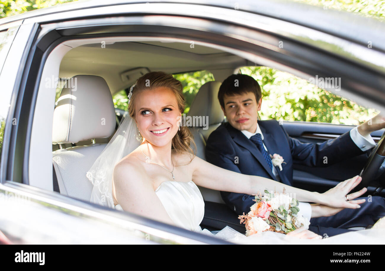 Bride and groom inside a car. They are happy Stock Photo - Alamy