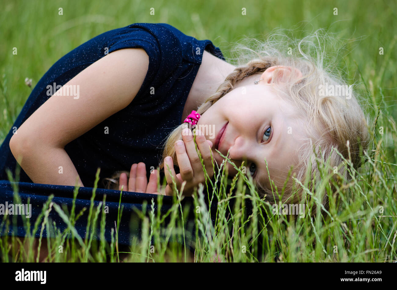 portrait of blond girl in green grass Stock Photo