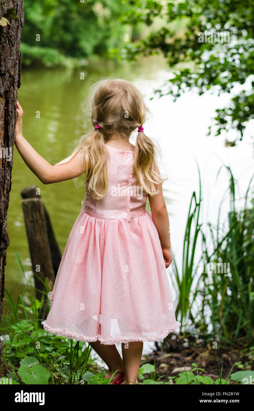 little blond girl looking to the pond Stock Photo
