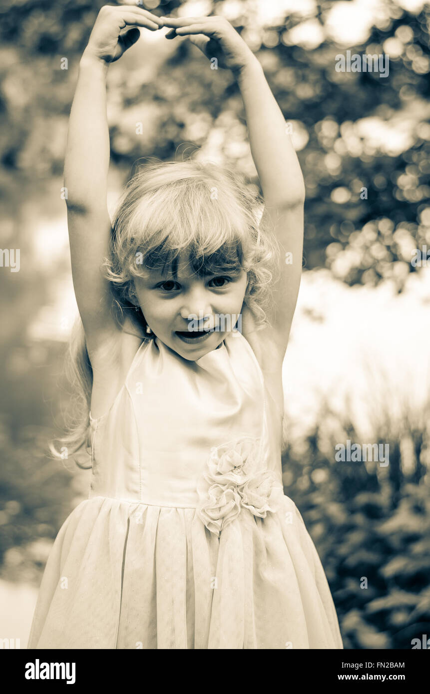 little blond girl dancing sepia effect Stock Photo