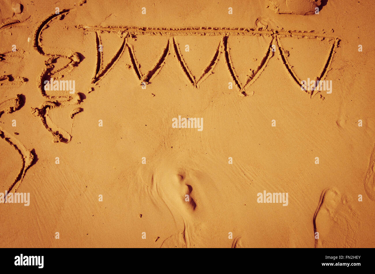 party symbols drown into sand on beach Stock Photo