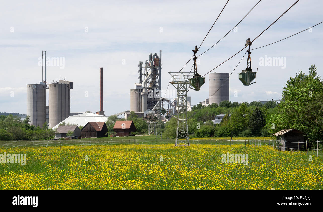 Material ropeway at an industrial plant with blooming spring meadow. Taken at the concrete factory in Dotternhausen, Germany. Stock Photo