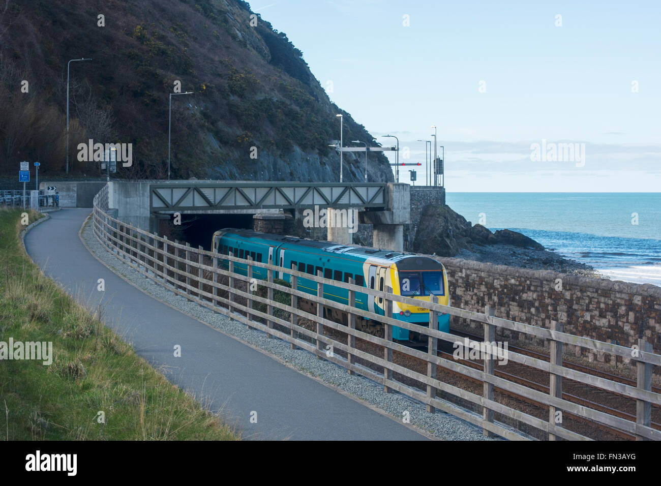 Arriva train exiting the Penmaen tunnel beside the A55 North wales Coast road near Conwy. Stock Photo