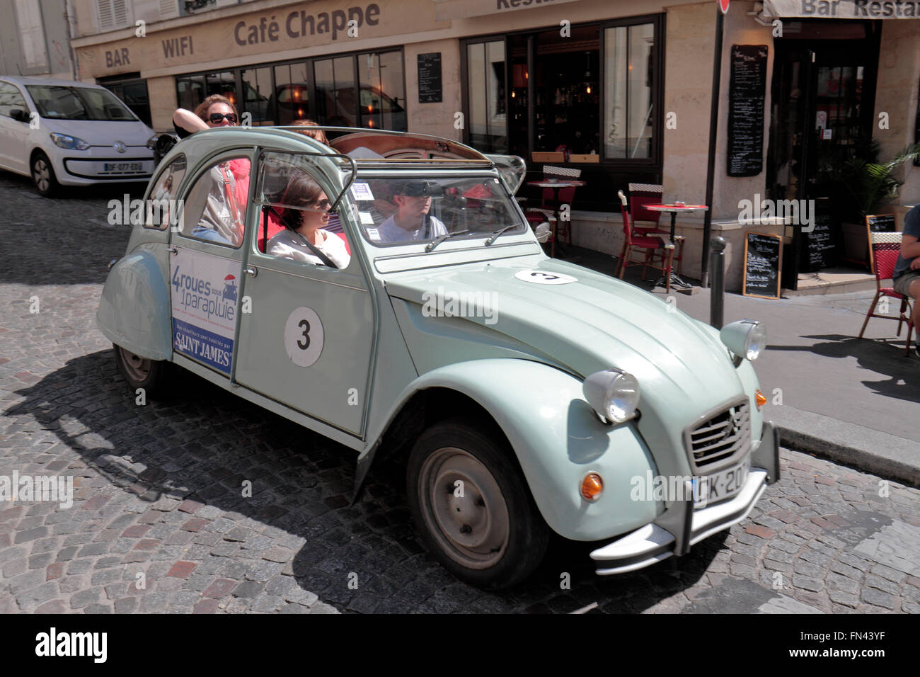 A 2CV rental car (from 4roues sous 1parapluie) touring Montmartre in Paris, France. Stock Photo