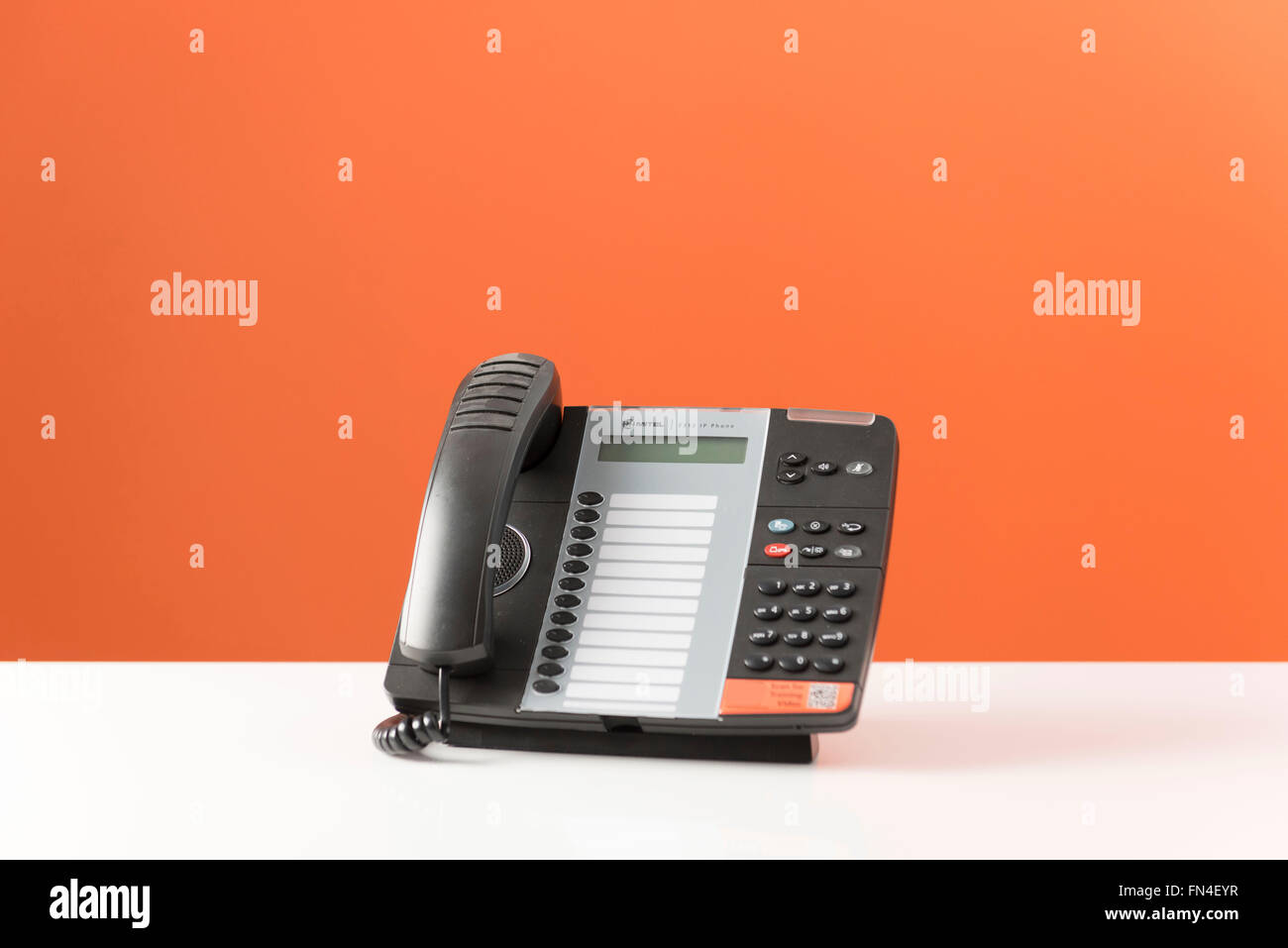 Office phone on an orange background. Stock Photo