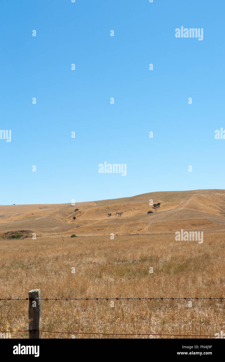 Vertical image over fence across plains to low rolling hills of dry drought affected farmland