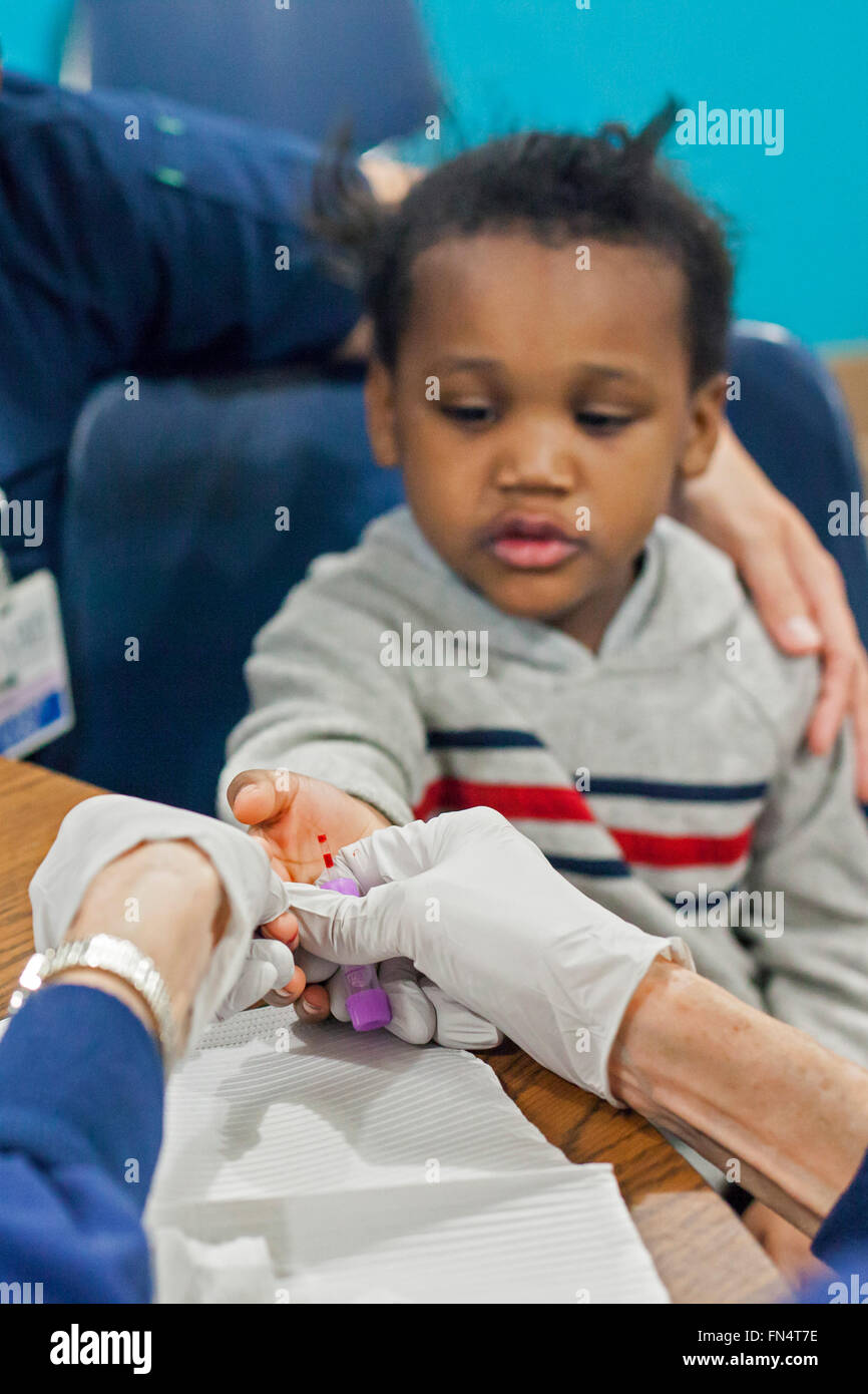 Flint, Michigan - A volunteer nurse collects a blood sample from Maylaysia Valsin-Cooley, 3, to test for lead exposure. Stock Photo