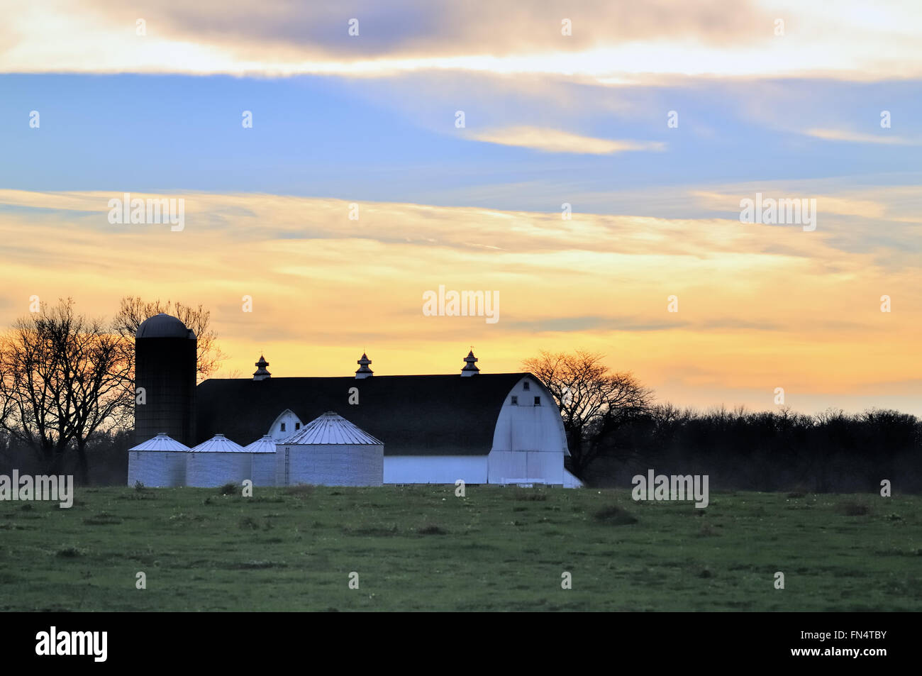 Day comes to a colorful end above a modern dairy farm in South Elgin, Illinois, USA. Stock Photo