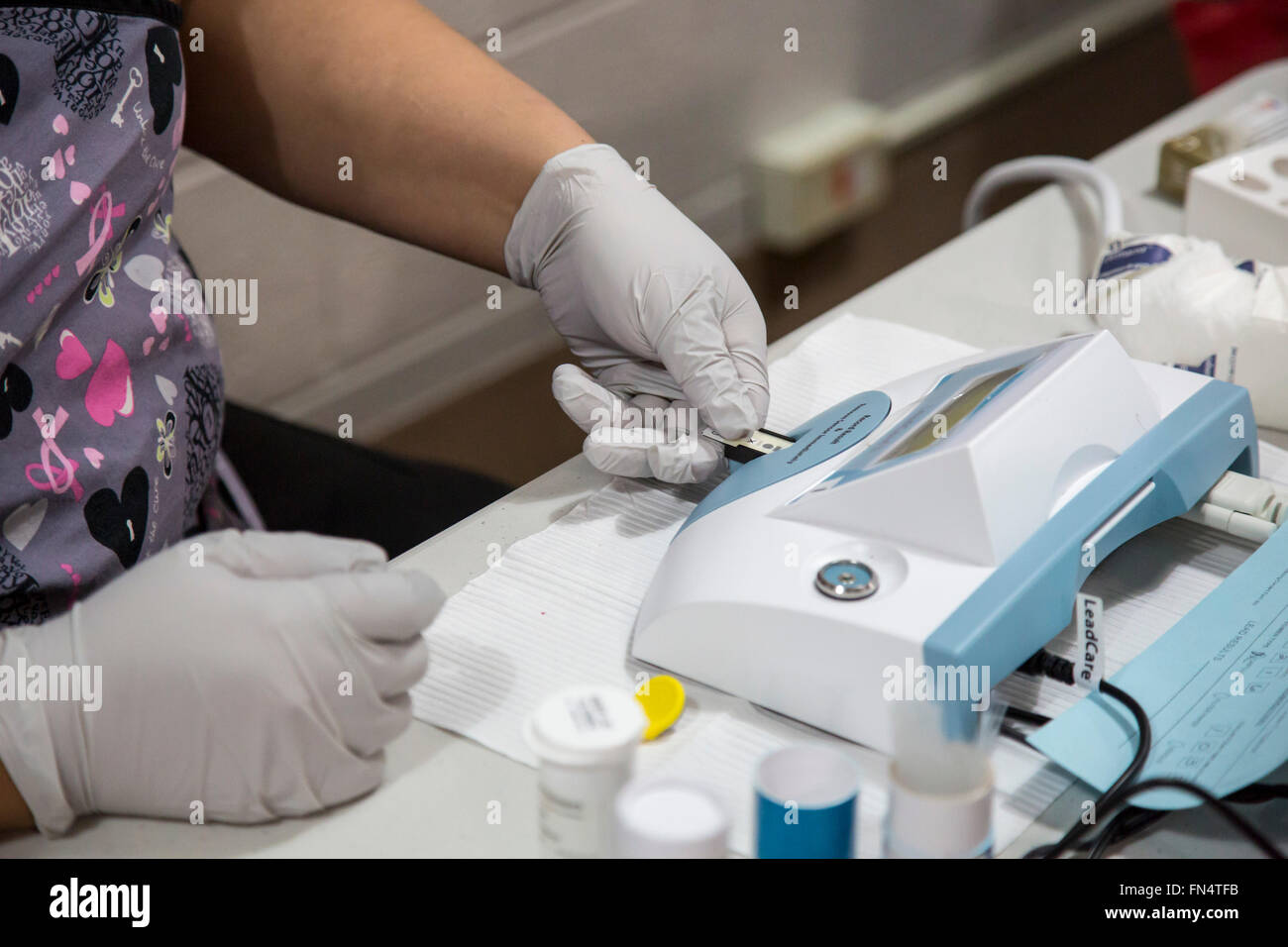 Flint, Michigan - A technican feeds a blood sample into a LeadCare Analyzer to check for the presence of lead. Stock Photo