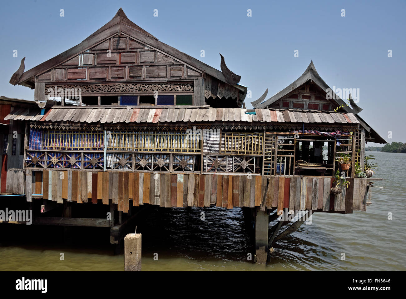 Old style Thai teak house converted into a restaurant on the Bang Pakong River Stock Photo