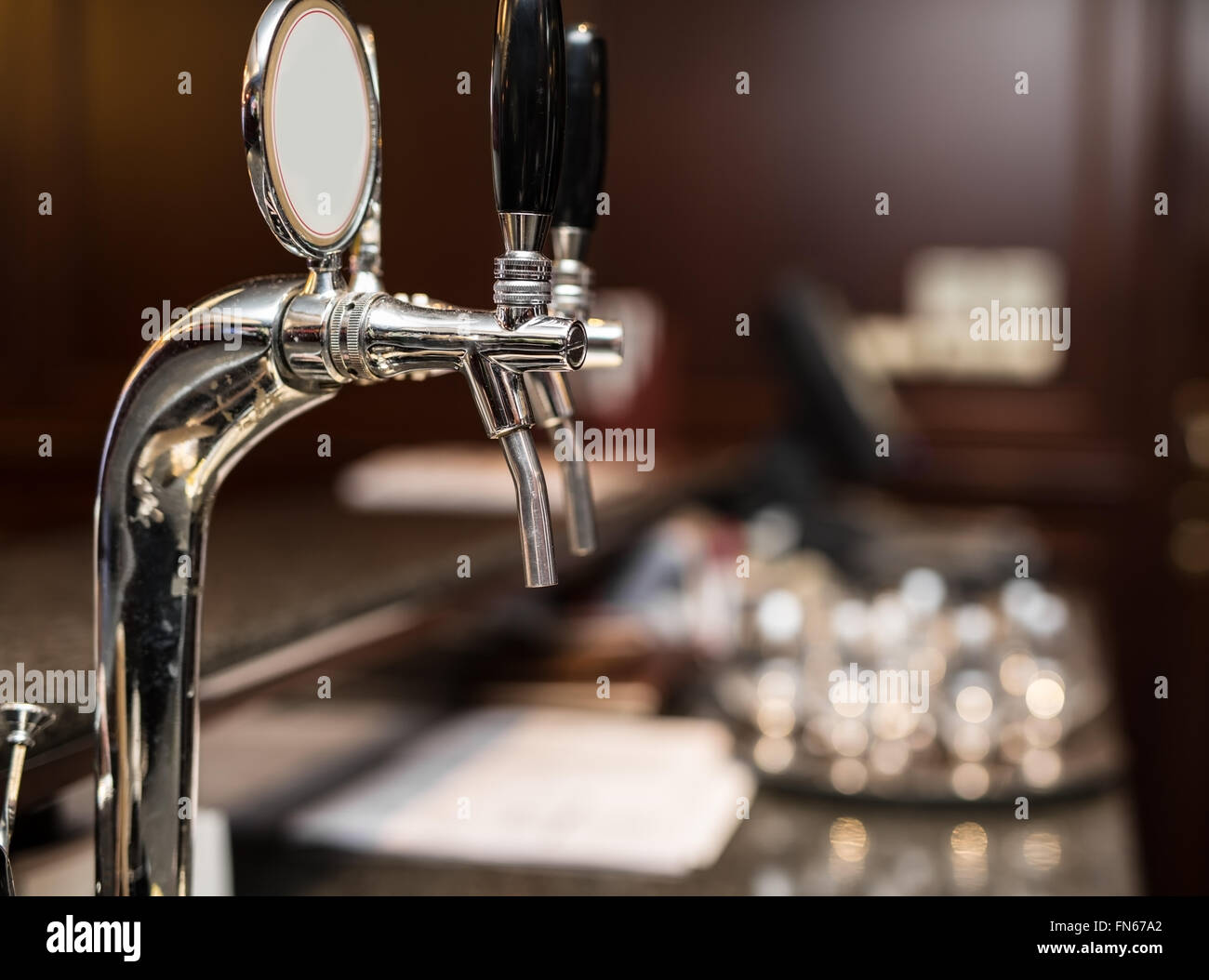 Beer tap. Blurred interior of pub on the background. Stock Photo
