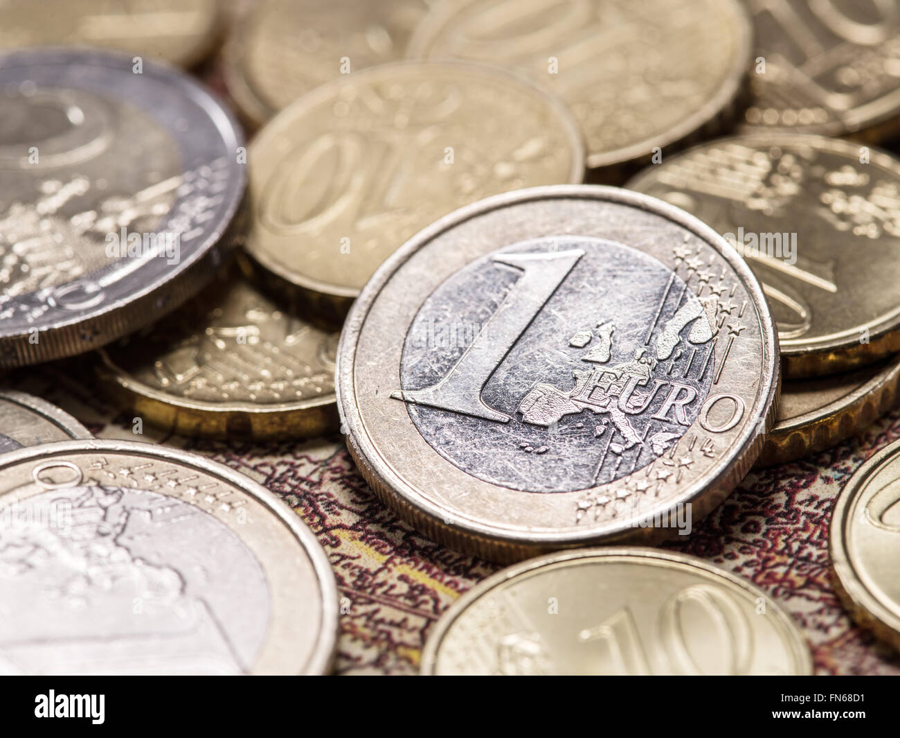 Euro coins over the old world map. Macro picture. Stock Photo