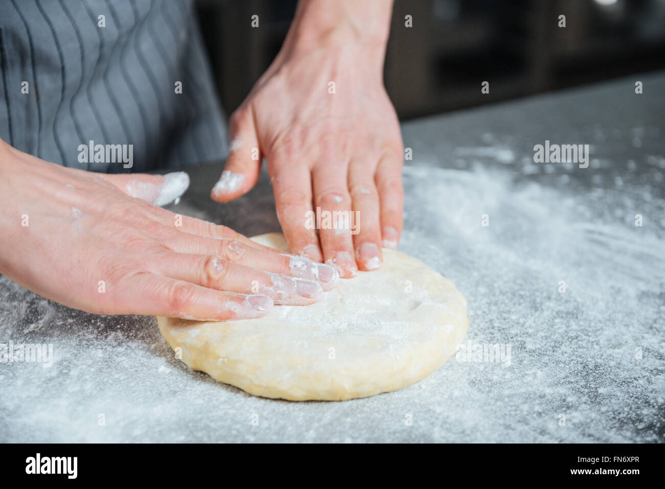 Closeup of male hands kneading dough on the table in kitchen Stock ...