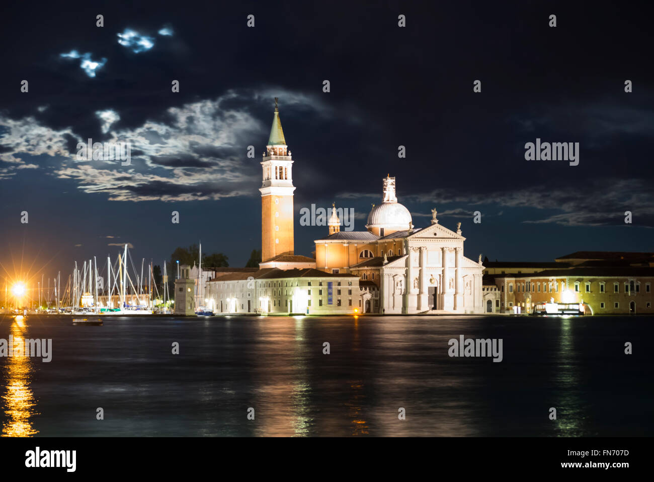 The island of San Giorgio Maggiore with the illuminated Church of San Giorgio Maggiore in Venice at a full moon night Stock Photo