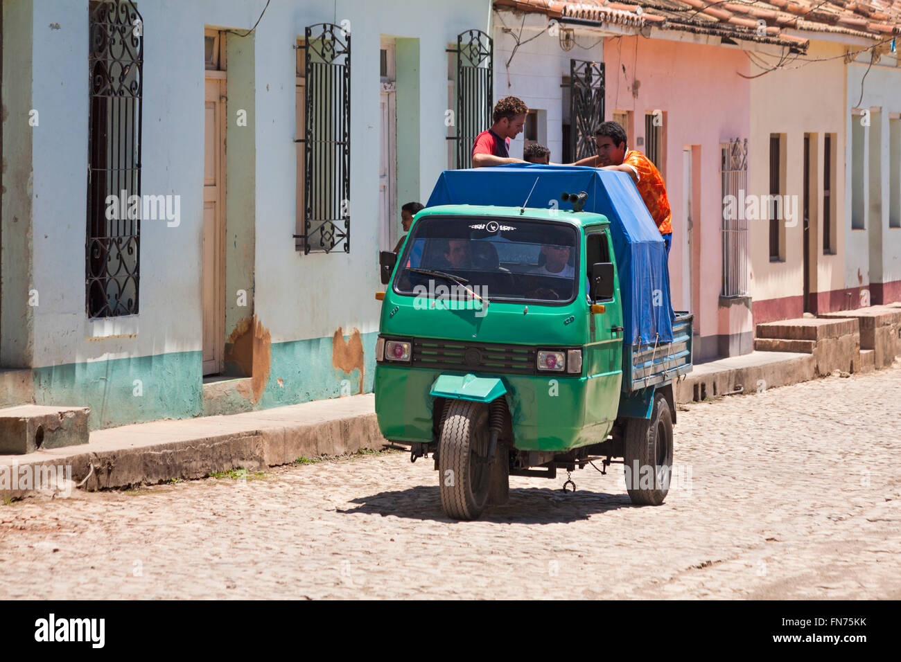 daily life in Cuba - Piaggio Ape three wheeled vehicle driving along cobbled street at Trinidad, Cuba Stock Photo