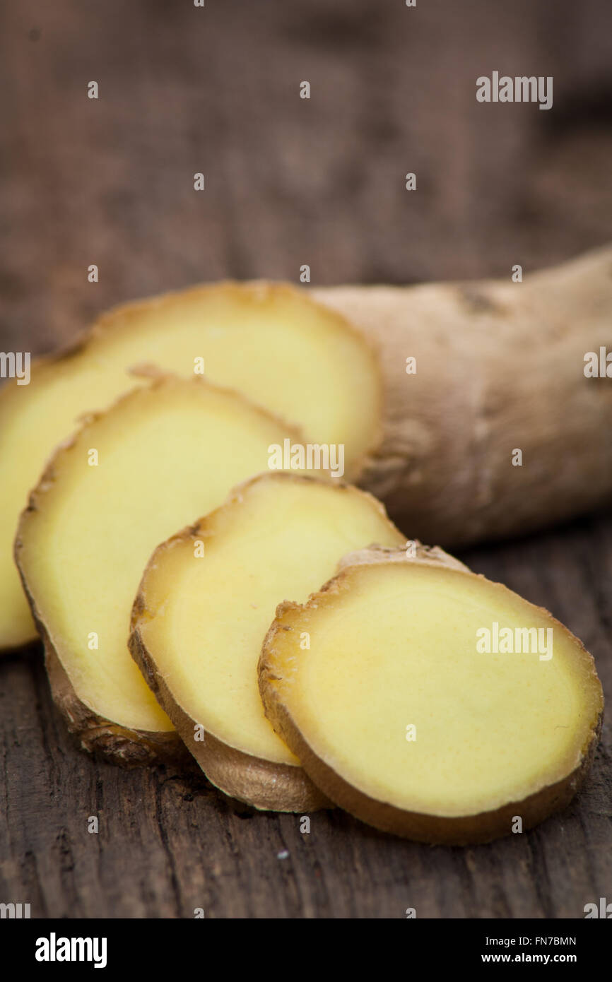 Fine sliced ginger root on wooden background Stock Photo