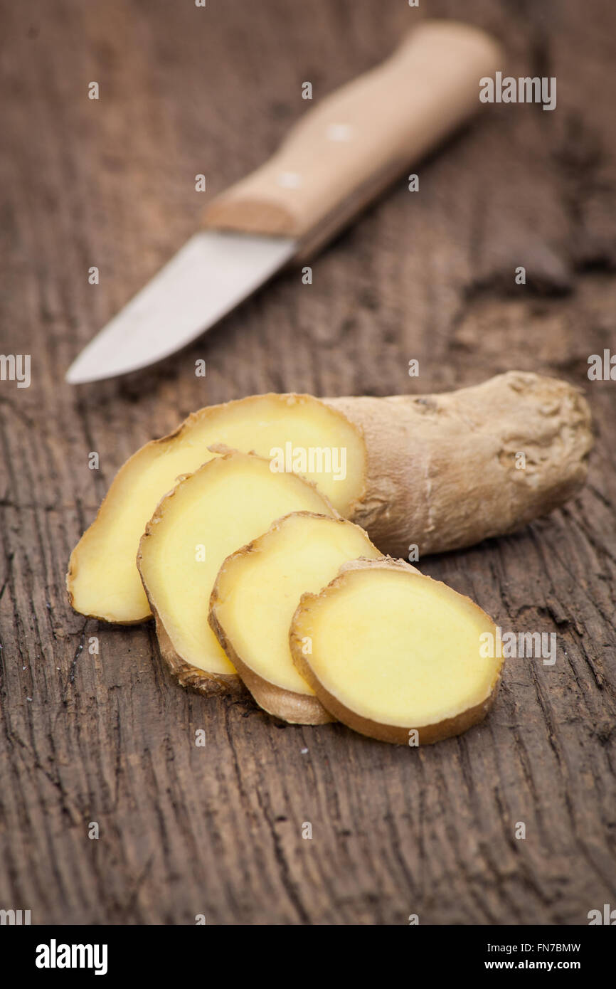 Fine sliced ginger root on wooden background Stock Photo