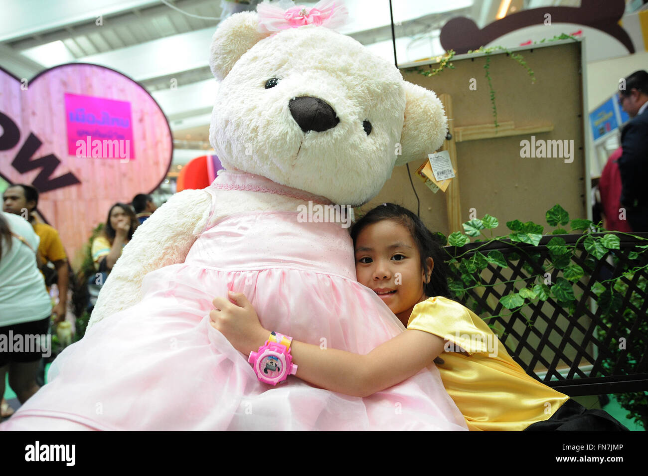 Bangkok, Thailand. 14th Mar, 2016. A girl hugs a bear doll during the