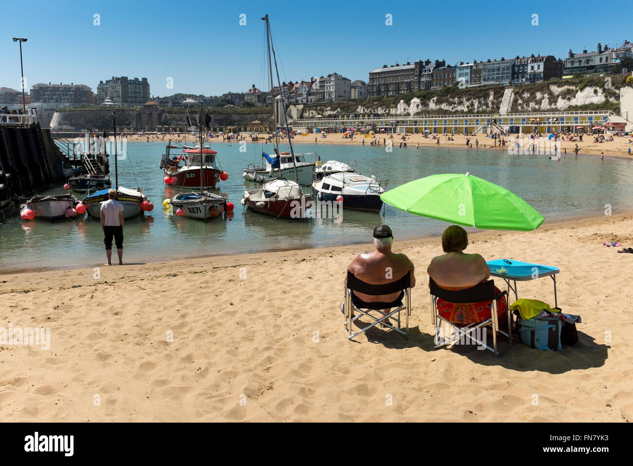 Middle age sunbathers on sandy beach in Broadstairs, Kent, UK Stock Photo