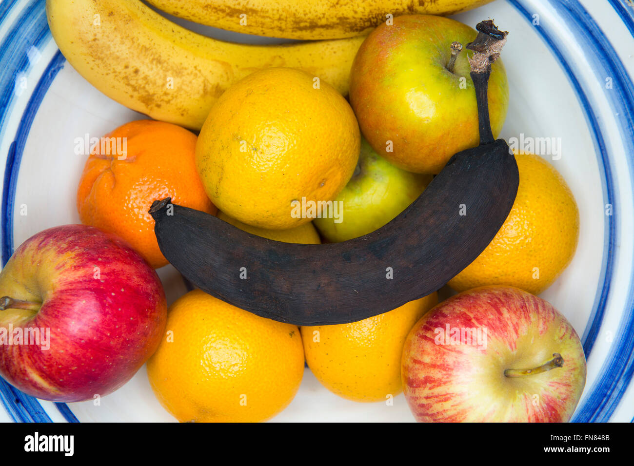 A bowl of fruit in a house, with oranges, pears, apples ,bananas adn