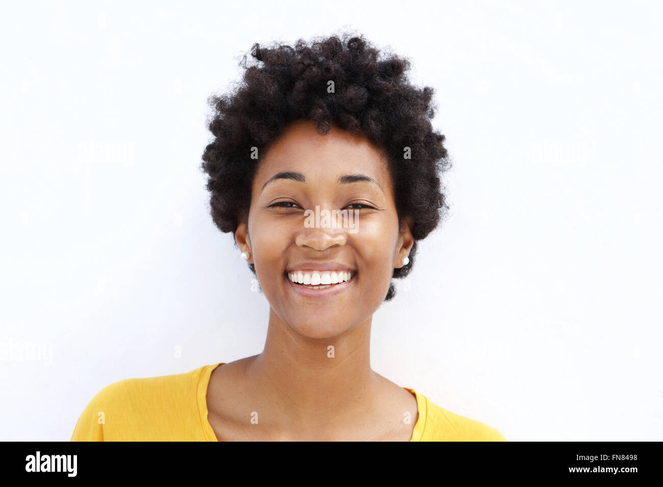 Closeup portrait of smiling young black woman against white background ...