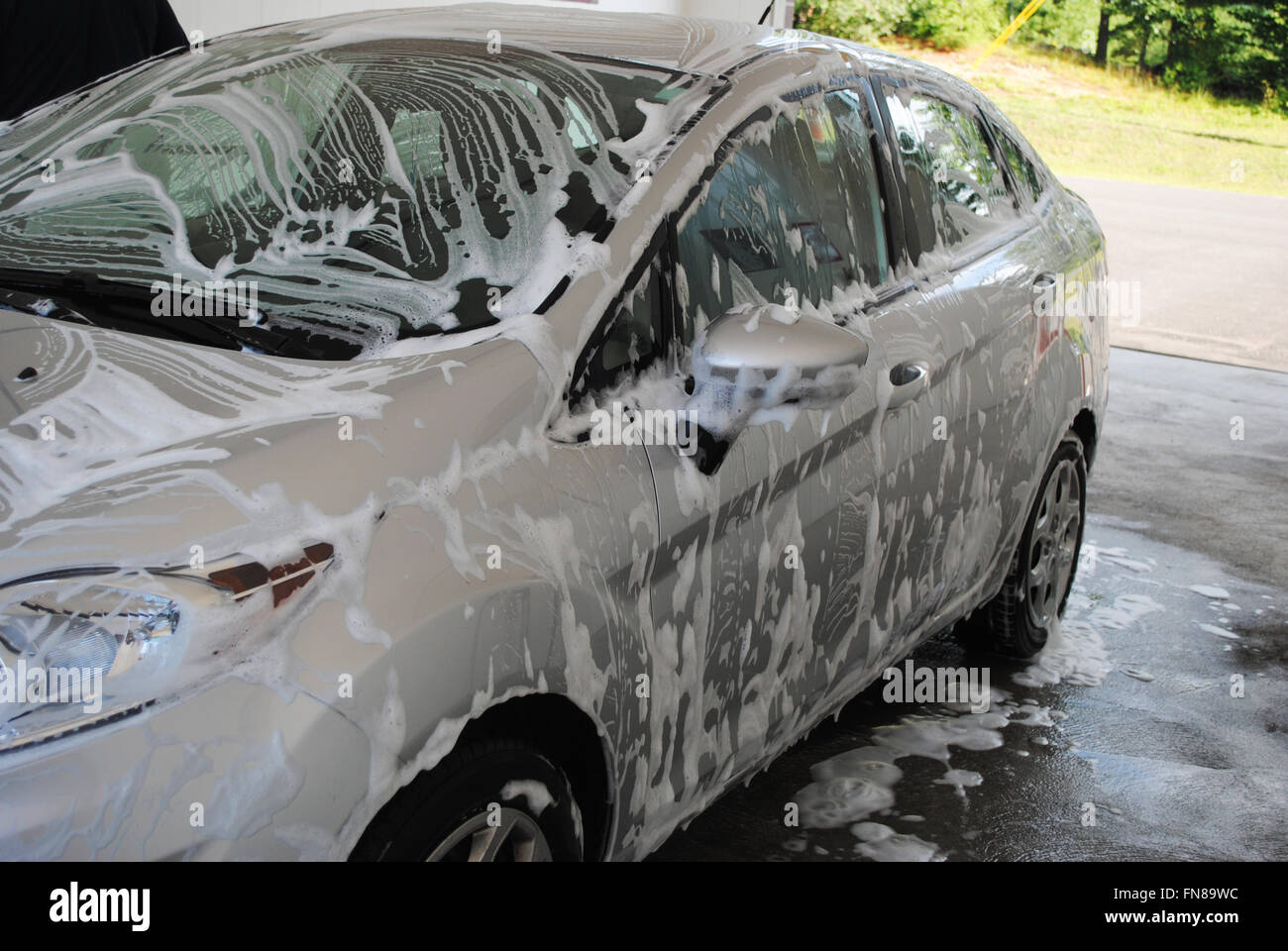 Car Covered with Soap Suds in a Washing Bay Stock Photo