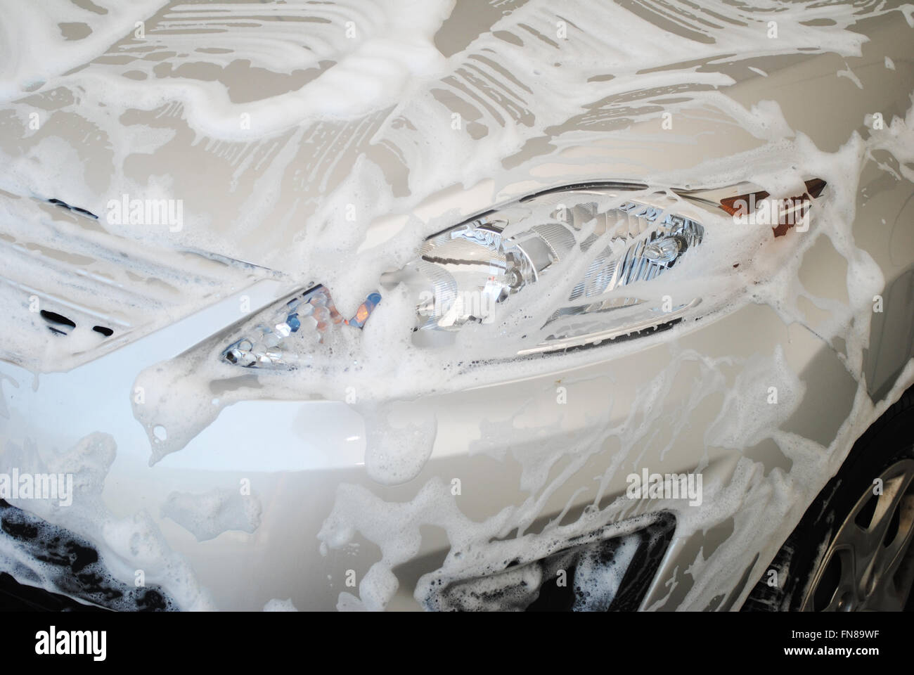 Car Covered with Soap Suds in a Washing Bay Stock Photo
