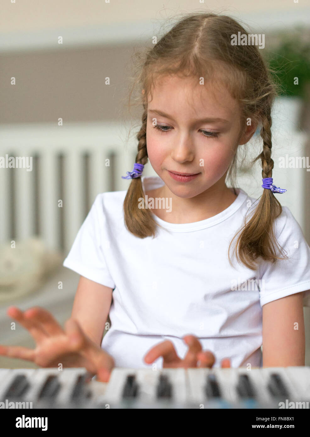 Cute little girl learning to play the piano Stock Photo - Alamy