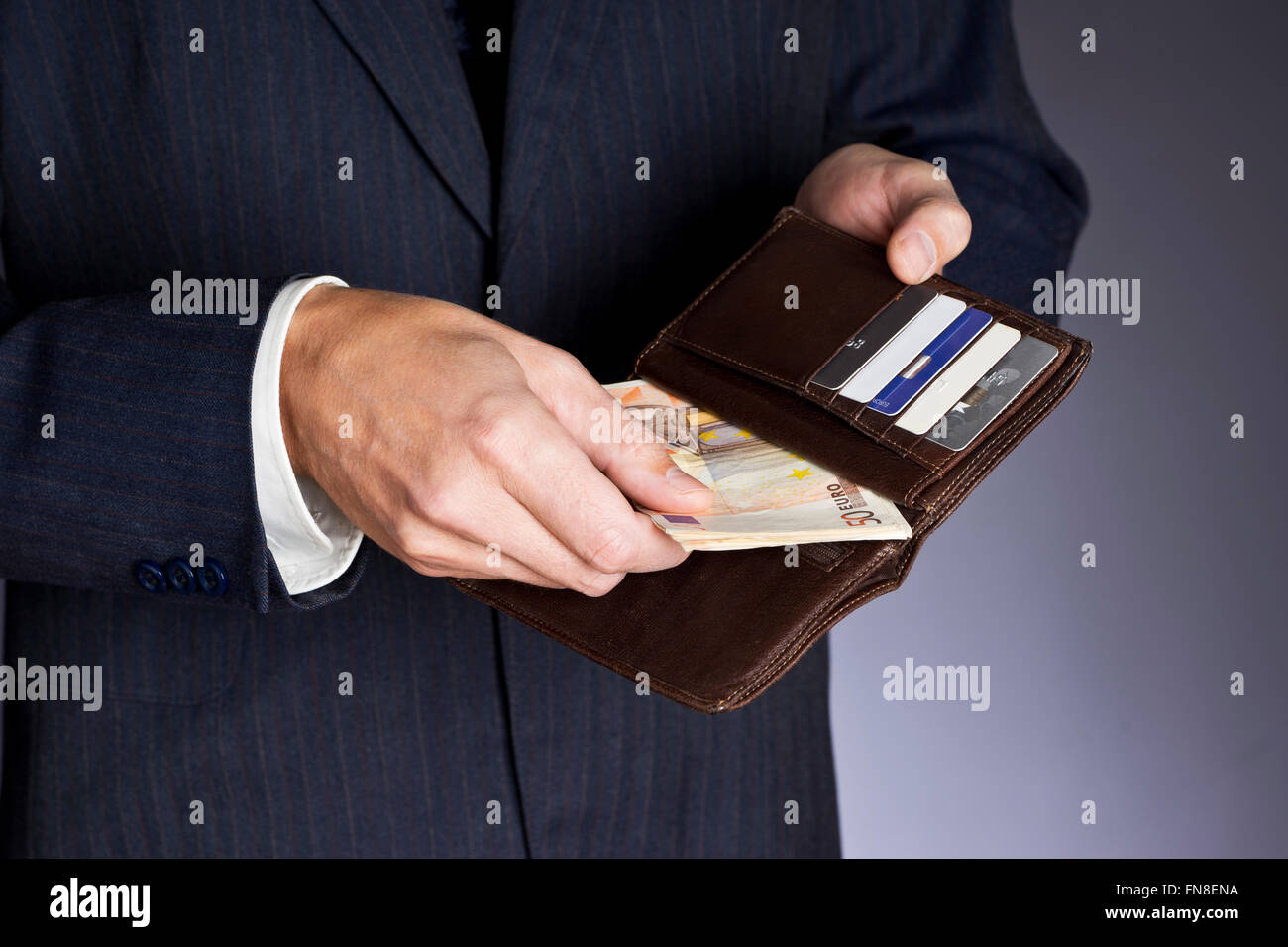 Brown leather wallet holding money and credit cards hi-res stock ...