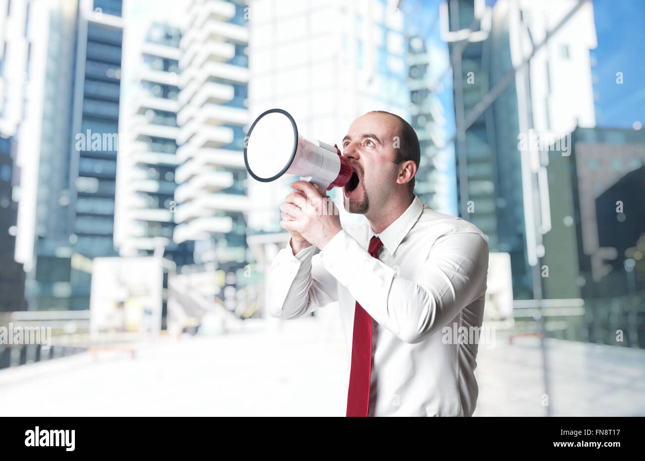 man with megaphone and modern building background Stock Photo