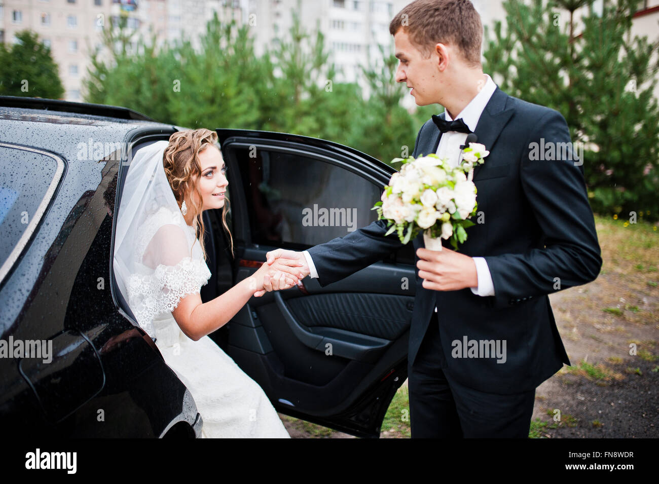 Groom and bride near wedding car Stock Photo - Alamy