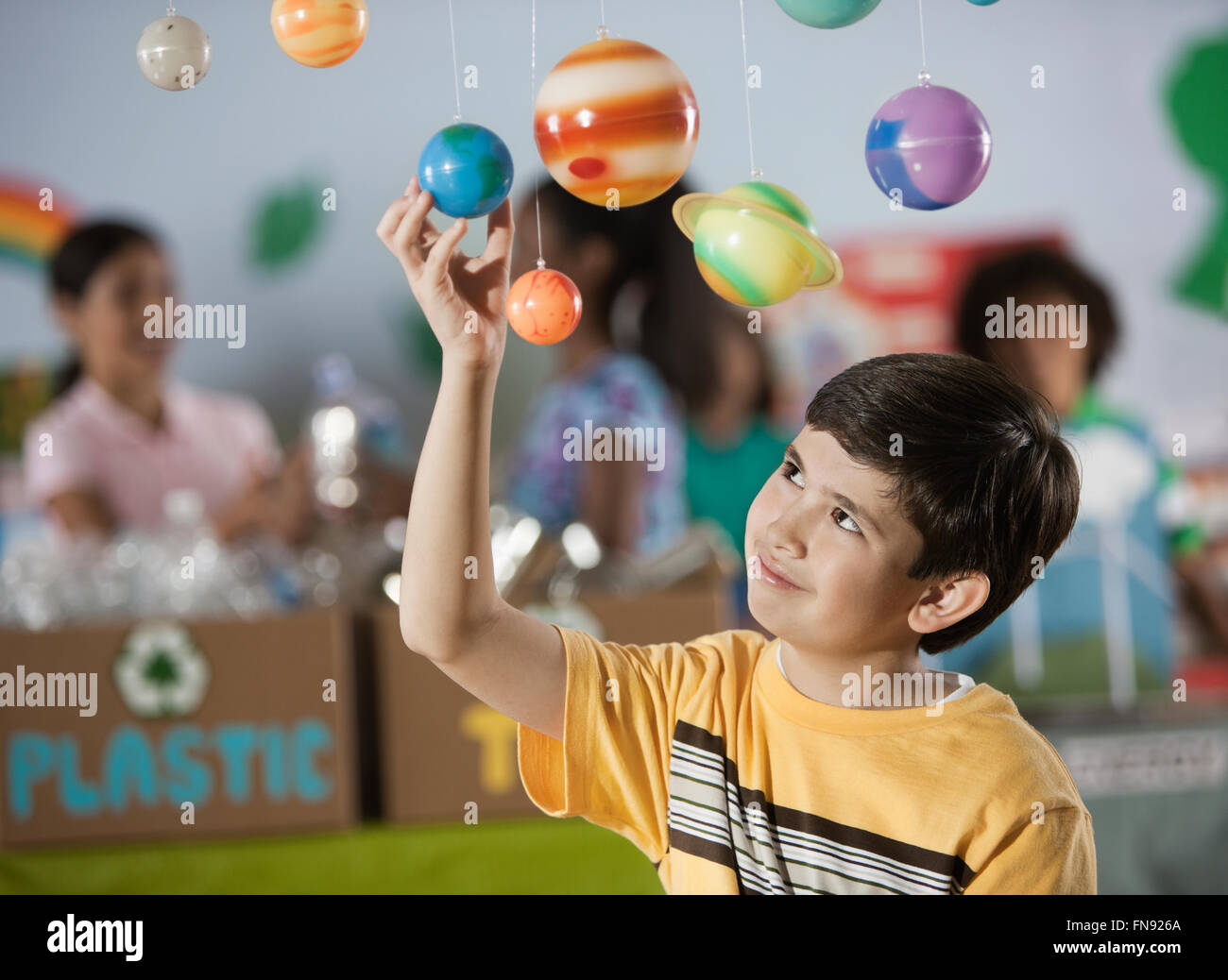 A boy looking up at a display of the planets, a presentation of the planetary system. Stock Photo