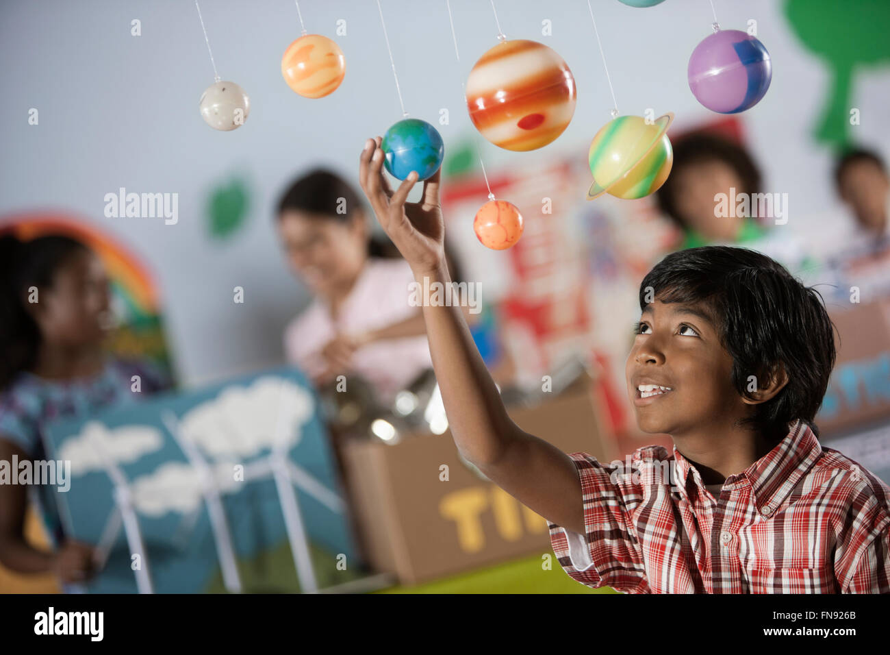 A boy looking up at a display of the planets, a presentation of the planetary system. Stock Photo