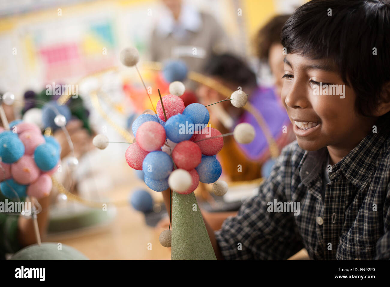 A group of students around a desk in a science lesson, creating molecular models. Stock Photo