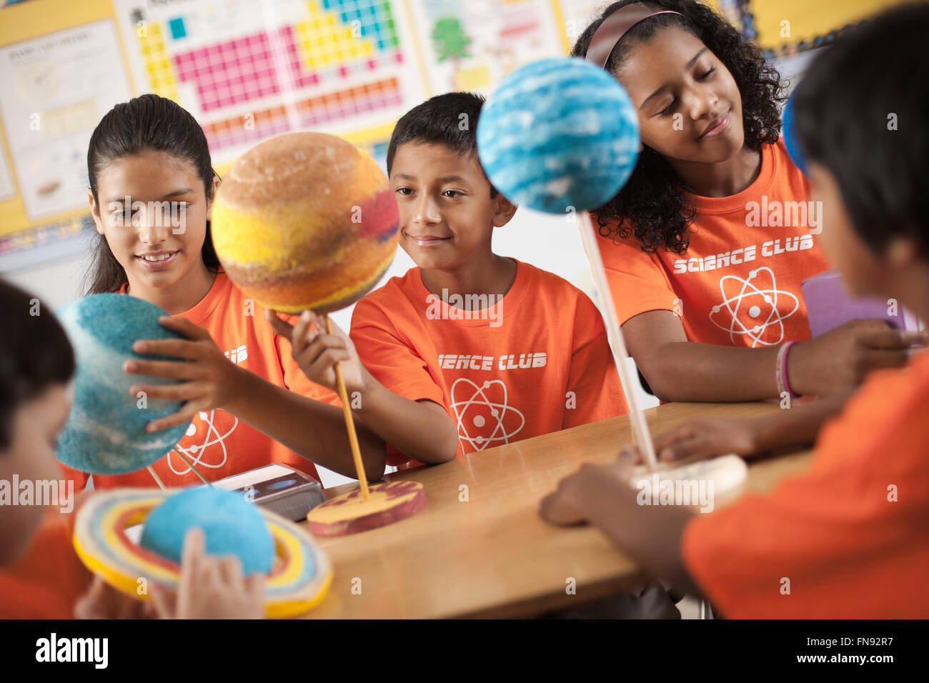 A group of girls and boys wearing the teeshirt of the Science Club, making molecular structure models. Stock Photo