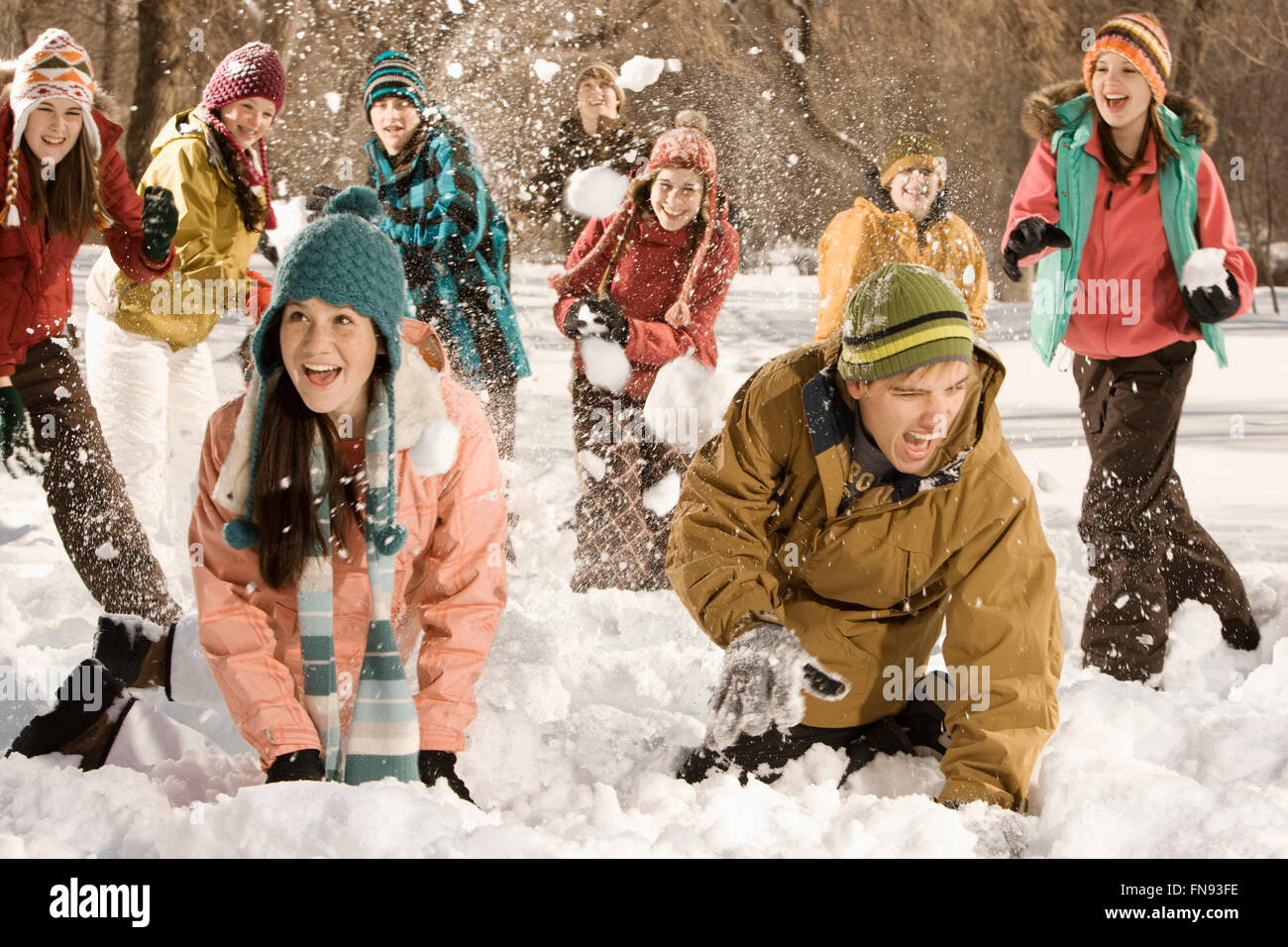 A group of children and young people having a snowball fight. Stock Photo