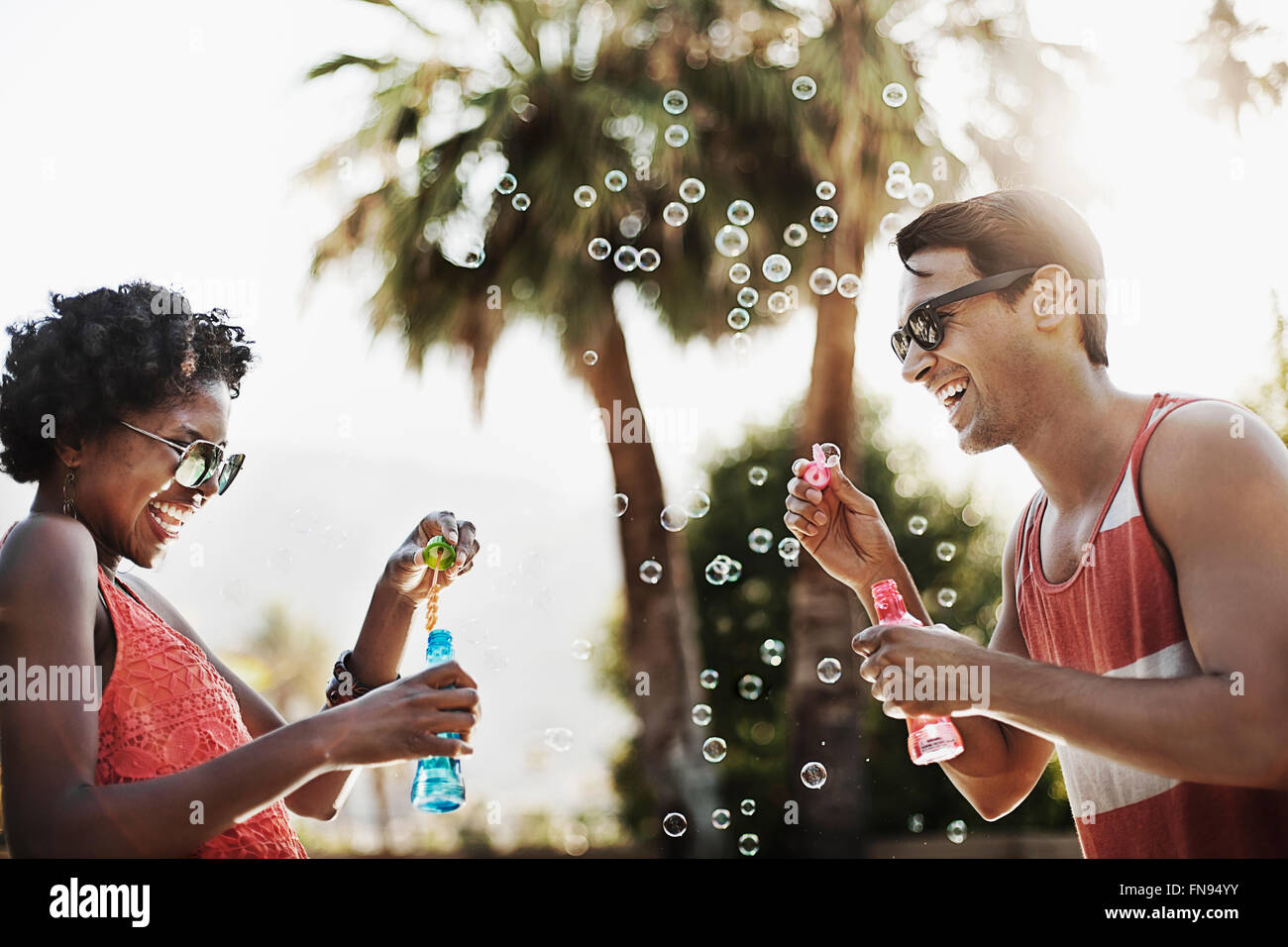 Two people blowing bubbles using bubble wands. Stock Photo